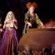 The Sanderson Sisters gather around a giant cauldron in a Disney Parks version of Hocus Pocus.
